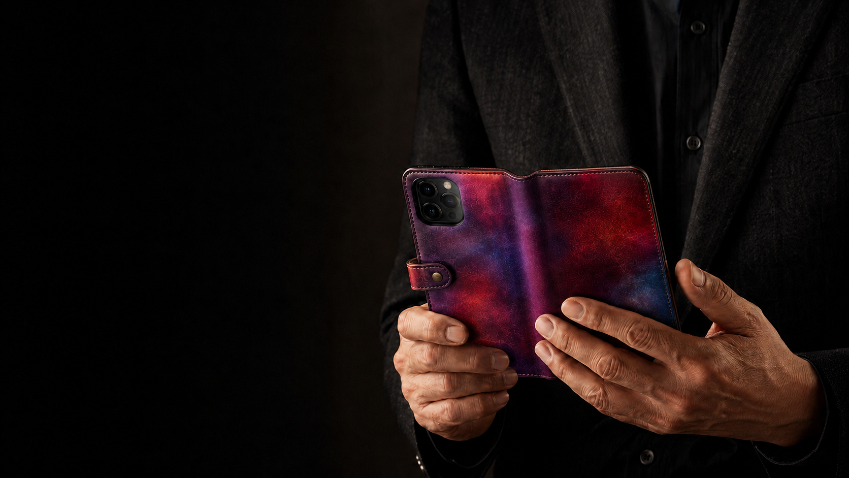 手染めの手帳型スマートフォンケースを使う大人の手元